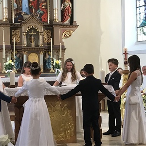 Die Erstkommunionskinder tanzen zu einem selbstgesungenen Lied um den Altar