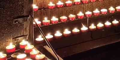 unzählige Lichter brennen am Opferstock in der Lichtergrotte