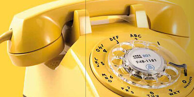 Gelbes Telefon mit Wählscheibe