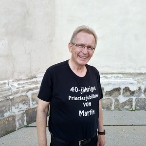 Jubilar Generalvikar Martin Korpitsch mit strahlendem Gesicht und dem Geschenk seiner Schwester. Das T-Shirt hat sie extra für ihn designed.