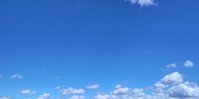 tiefblauer Himmel mit Wolken besprenkelt