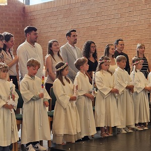 Erstkommunionkinder mit Taufpaten und Taufkerzen