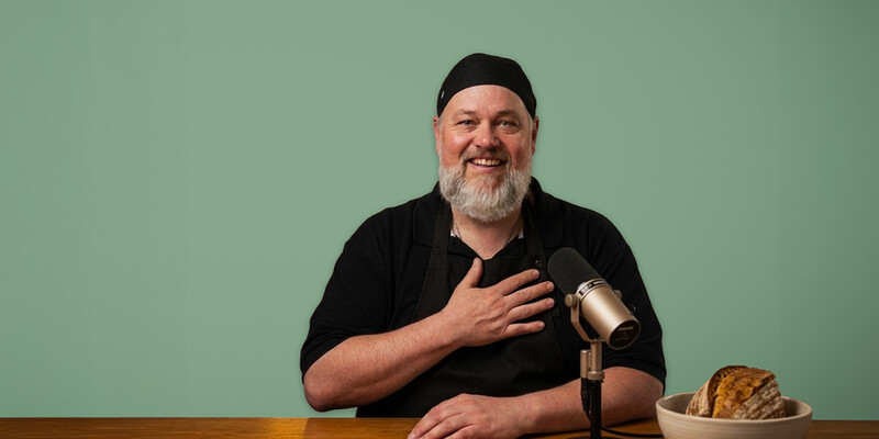 Pfarrer Norbert Filipitsch mit Podcastmikrofon und Brot.