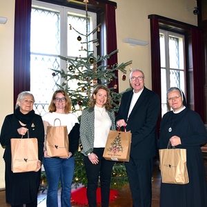 kfb-Vorsitzende Roselinde Strommer, kfb-Geschäftsführerin Rebecca Gerdenitsch-Schwarz, interim. Anstaltsleiterin Julia Macheiner, Diözesanbischof Ägidius Zsifkovics und Schwester Pia mit einigen Geschenksackerln von der Aktion 'Freude teilen'
