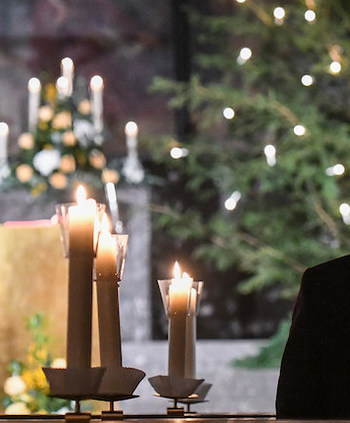 Ein Mann kniet neben Kerzen vor einer Christmette in der Kirche Sankt Remigius in Bonn am 24. Dezember 2020.
