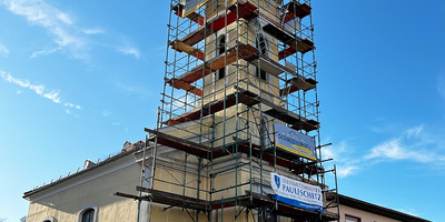 Kirche mit eingerüstetem Turm.
