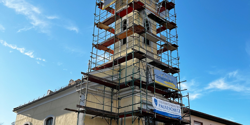 Kirche mit eingerüstetem Turm.