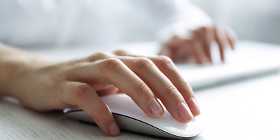 Hand mit Computermaus auf einem Tisch
