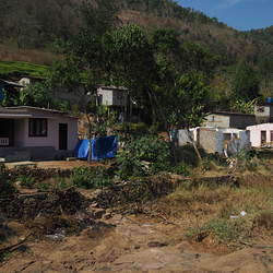 Links im Bild ein mit Hilfe aus dem Burgenland wiederaufgebautes Familienhaus, daneben Ruinen der zerstörten Häuser