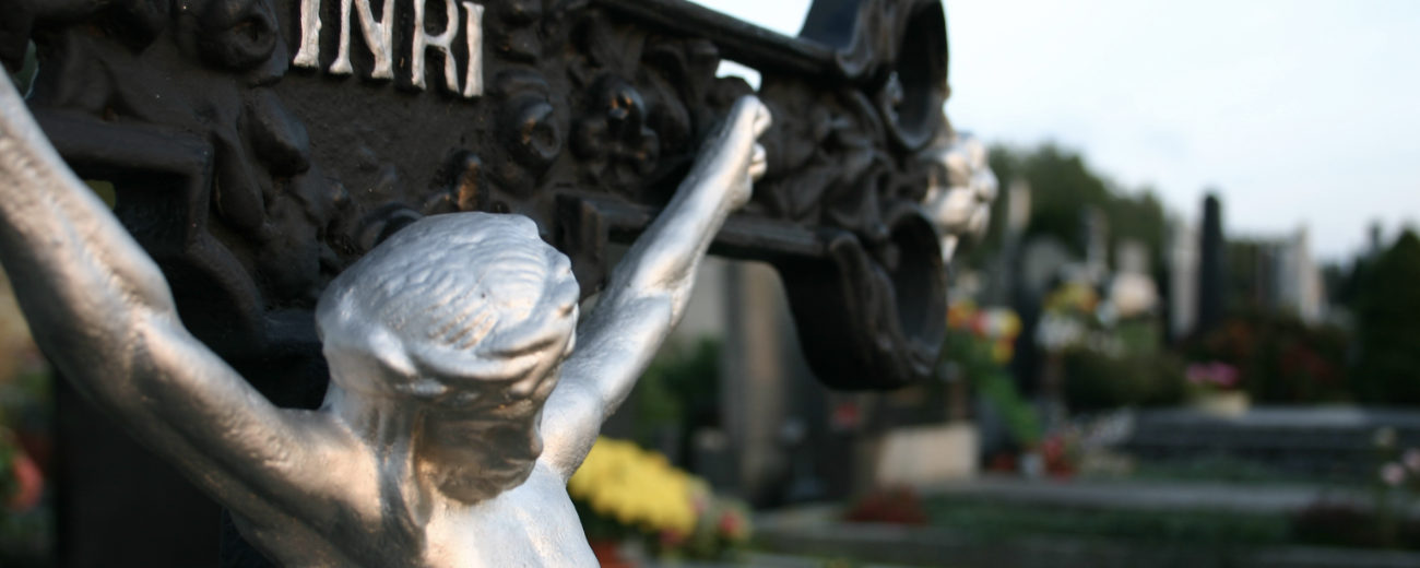 EIsenkreuz auf einem Friedhof mit dem Gekreuzigten und der Aufschrift INRI.